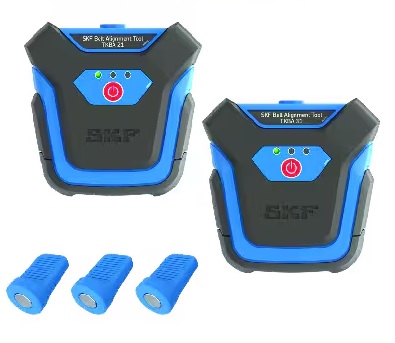 Na zdjęciu widać laserowy przyrząd do osiowania k&oacute;ł pasowych SKF TKBA 21 w czarnej, poręcznej walizce transportowej. Zestaw składa się z dw&oacute;ch gł&oacute;wnych moduł&oacute;w: nadajnika laserowego i odbiornika. Oba urządzenia są w kolorze czarnym z charakterystycznymi dla marki SKF, niebieskimi i białymi elementami. Na odbiorniku widoczne są wskaźniki LED, kt&oacute;re sygnalizują prawidłowe osiowanie. Zestaw jest ułożony w specjalnej piance, kt&oacute;ra chroni komponenty przed uszkodzeniami.