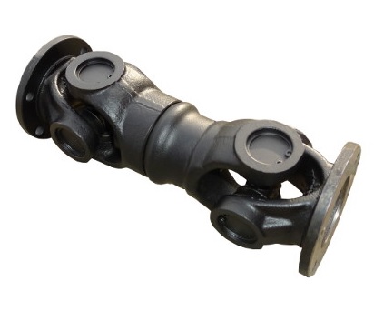 Dynamiczne ujęcie z g&oacute;ry, prezentujące specjalistyczne środowisko warsztatowe, skupione na regeneracji i serwisowaniu wał&oacute;w napędowych do ciężkich maszyn. Na pierwszym planie, na stole warsztatowym leży zdemontowany wał napędowy, wok&oacute;ł kt&oacute;rego starannie ułożono r&oacute;żne narzędzia, takie jak klucze, szlifierki i przyrządy pomiarowe. Wykwalifikowany technik, ubrany w gogle ochronne i rękawice robocze, skrupulatnie sprawdza element wału, podkreślając precyzję wymaganą w tym procesie.  W tle widoczna jest nowoczesna wyważarka z kolejnym wałem napędowym, kt&oacute;ry jest bezpiecznie zamontowany i gotowy do dynamicznego wyważania. Cyfrowy wyświetlacz maszyny pokazuje odczyty techniczne, co podkreśla zaawansowaną technologię.