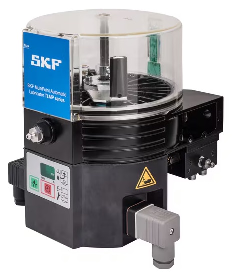 Zaawansowany system centralnego smarowania TLMP 1008/230V SKF Obraz jest ucieleśnieniem kompaktowej, zintegrowanej automatyzacji smarowania, które są synonimami zaawansowanych systemów SKF. Kompozycja łączy w sobie sterylny, high-tech'owy wizerunek kompletnej jednostki pompującej TLMP 1008 z profesjonalizmem i dostępnością, jakie budzi autoryzowany polski dystrybutor DAKAM. Dominują w niej ikoniczne barwy SKF – intensywny niebieski – oraz przezroczyste elementy zbiornika. W centrum uwagi, na czystej, industrialnej powierzchni (np. metalowym stole warsztatowym lub białym tle), znajduje się automatyczna smarownica wielopunktowa SKF TLMP 1008/230V: • Zintegrowana jednostka: Prezentowana jest kompletna, kompaktowa jednostka, która łączy w sobie pompę, zbiornik i sterownik. • Kluczowy detal – 8 wyjść: Wyraźnie widoczny jest blok dystrybucyjny z maksymalnie 8 wyjściami (portami). To wizualnie komunikuje jej przeznaczenie do bezpośredniego smarowania wielopunktowego wielu elementów maszyny z jednej, centralnej jednostki. • Przezroczysty zbiornik: Widoczny jest przezroczysty zbiornik na smar (o pojemności ok. 1 litra) z mieszadłem, co umożliwia łatwą wizualną kontrolę poziomu środka smarnego. • Zasilanie 230V: Widoczny jest kabel zasilający (sieciowy), co podkreśla zasilanie napięciem 230V AC i możliwość samodzielnej pracy (standalone) bez konieczności integracji z PLC maszyny. • Marka Premium: Na solidnej obudowie (niebieskiej lub czarnej) widoczne jest wyraźne, oryginalne logo "SKF" oraz oznaczenie modelu "TLMP 1008 / 230VAC", co jest gwarancją autentyczności i światowej klasy technologii. Tło jest subtelnie rozmyte (efekt bokeh), ale jednoznacznie wskazuje na profesjonalną dystrybucję na terenie Polski: • Nowoczesny magazyn DAKAM: W tle widać rzędy wysokich regałów magazynowych, wypełnionych uporządkowanymi, oryginalnymi, niebieskimi opakowaniami SKF. Duża ilość towaru na stanie wizualnie potwierdza status "sprawdzonego dystrybutora". • Logo Dystrybutora: W dyskretnym, ale widocznym miejscu umieszczone jest logo DAKAM, z dopiskiem "Autoryzowane Centrum Systemów Smarowania" lub "Autoryzowany Dystrybutor SKF". Obraz niesie jasny komunikat: "Jako autoryzowany polski dystrybutor DAKAM, posiadamy na stanie kompaktowe smarownice wielopunktowe SKF TLMP 1008/230V, idealne do automatycznego smarowania wielu punktów w maszynach, pracujące jako samodzielna jednostka zasilana z sieci 230V".