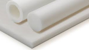 Obraz jest ucieleśnieniem kompleksowej oferty w dziedzinie specjalistycznych tworzyw konstrukcyjnych, skupiając się na Teflonie PTFE. Kompozycja w unikalny sposób łączy sprzedaż surowych półfabrykatów PTFE z precyzyjną usługą obróbki CNC. Dominują w niej charakterystyczne dla PTFE barwy – mleczno-biała, gładka powierzchnia – oraz sterylne, metaliczne akcenty warsztatu obróbczego. Całość jest osadzona w kontekście autoryzowanego polskiego dystrybutora DAKAM. W centrum uwagi, na czystym, metalowym stole warsztatowym (lub białym tle), znajduje się starannie zaaranżowana kompozycja "przed i po": •	Półfabrykaty (Sprzedaż): o	Płyta PTFE: Starannie docięty fragment płyty. Jej powierzchnia jest gładka i charakterystycznie "woskowa" w dotyku. o	Pręt PTFE: Solidny, cylindryczny wałek. o	Tuleja PTFE: Pusta w środku rura, pokazująca wszechstronność formy. Wszystkie elementy mają jednolity, mleczno-biały kolor, typowy dla czystego PTFE. •	Kluczowy detal (Obróbka): o	Gotowy detal: Obok surowych półfabrykatów leży precyzyjnie wykonany, gotowy komponent obrobiony z PTFE. Może to być np. uszczelka, tuleja ślizgowa, element izolacyjny, czy też komponent o złożonym kształcie z wyfrezowanymi rowkami i otworami. Precyzyjne krawędzie i gładka powierzchnia obrobionego elementu podkreślają mistrzostwo wykonania. •	Precyzja: Obok gotowego detalu leży suwmiarka cyfrowa, co wizualnie komunikuje precyzję i kontrolę wymiarową usługi obróbki. Tło jest subtelnie rozmyte (efekt bokeh), ale jednoznacznie wskazuje na podwójne kompetencje DAKAM: •	Po lewej (Obróbka): Widoczny jest fragment nowoczesnej maszyny CNC (frezarki lub tokarki), co wizualnie potwierdza zdolność do wykonywania precyzyjnej obróbki tworzyw na miejscu. •	Po prawej (Sprzedaż/Magazyn): W tle widać rzędy wysokich regałów magazynowych, wypełnionych długimi prętami i tulejami PTFE składowanymi w specjalnych tubach lub na stojakach oraz dużymi płytami (formatkami) PTFE składowanymi płasko. To wizualnie potwierdza dużą dostępność magazynową. •	Logo Dystrybutora: W dyskretnym, ale widocznym miejscu umieszczone jest logo DAKAM, z dopiskiem "Centrum Tworzyw Konstrukcyjnych" lub "Sprzedaż i Obróbka CNC". Obraz niesie jasny komunikat: "Jako sprawdzony polski dystrybutor DAKAM, posiadamy na stanie pełen asortyment Teflonu PTFE (płyt, prętów i tulei), które docinamy i obrabiamy na gotowo według Twojego rysunku technicznego, zapewniając idealne właściwości ślizgowe i odporność chemiczną".